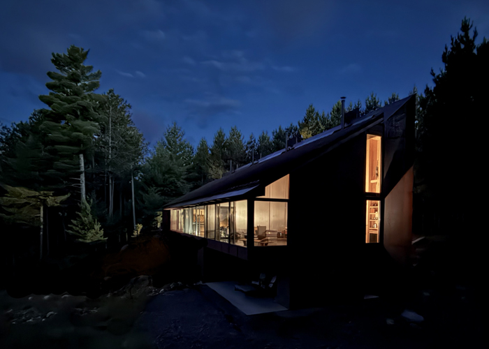 Boreal forest studio lit up at dusk